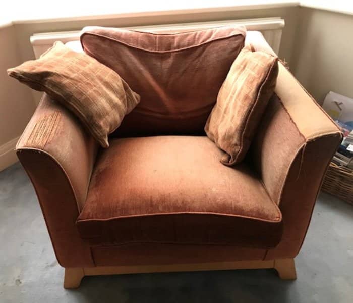 Old brown armchair in need of reupholstering