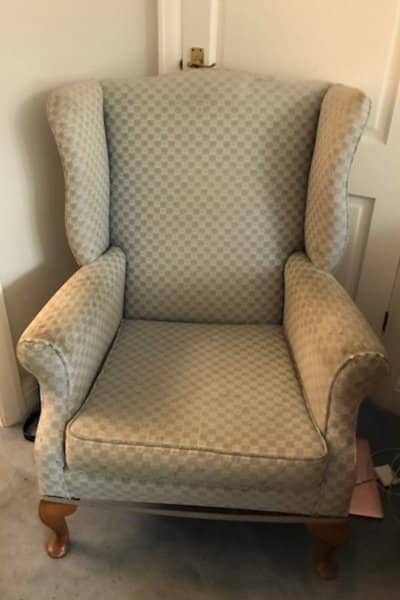 Old cream armchair in need of reupholstering