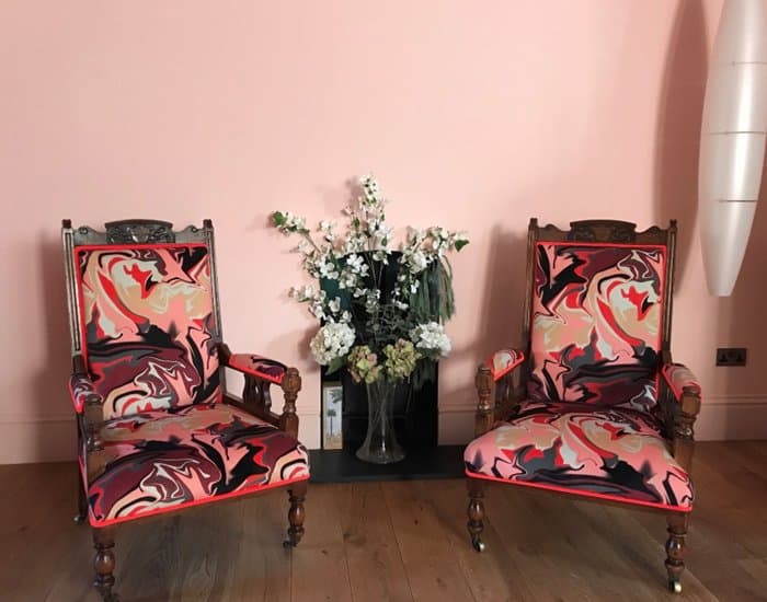 Two chairs on wheels reupholsterd in patterned pink velvet