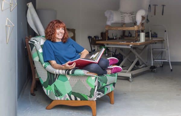 Business owner Sharon O'Connor reads on an upholstered armchair