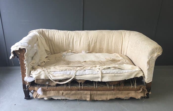 Old sofa undergoing upholstery project in the workshop