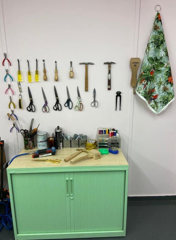 Upholstery supplies and tools lined up on wall in Vintique Upholstery workshop