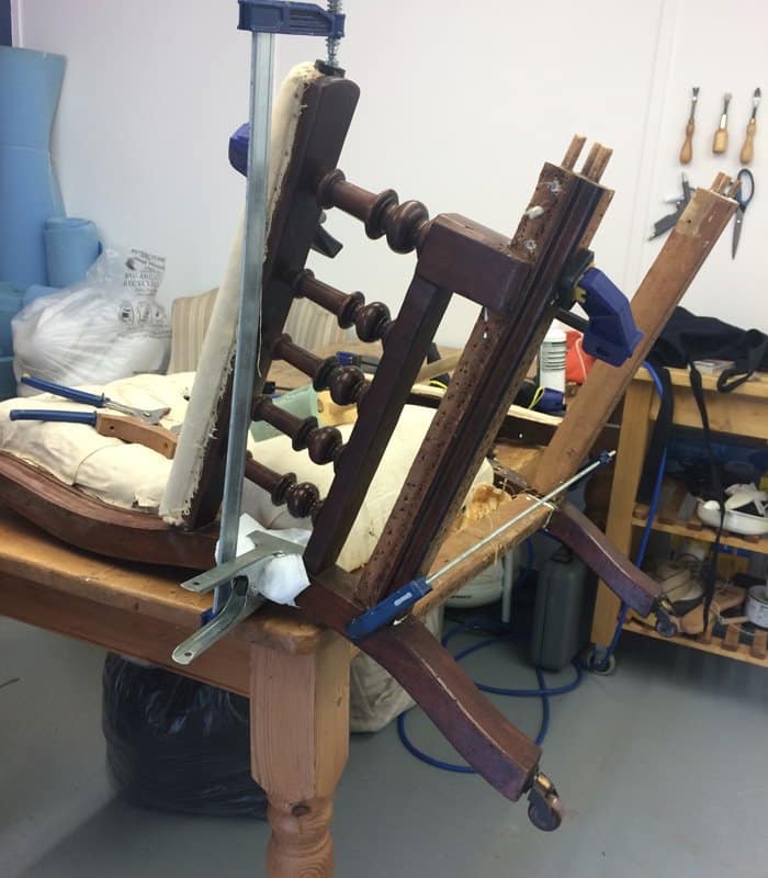 Dismantled chair being reassembled during upholstery process