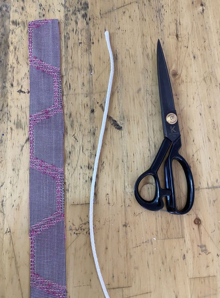 Upholstery fabric with scissors and string ready for single piping