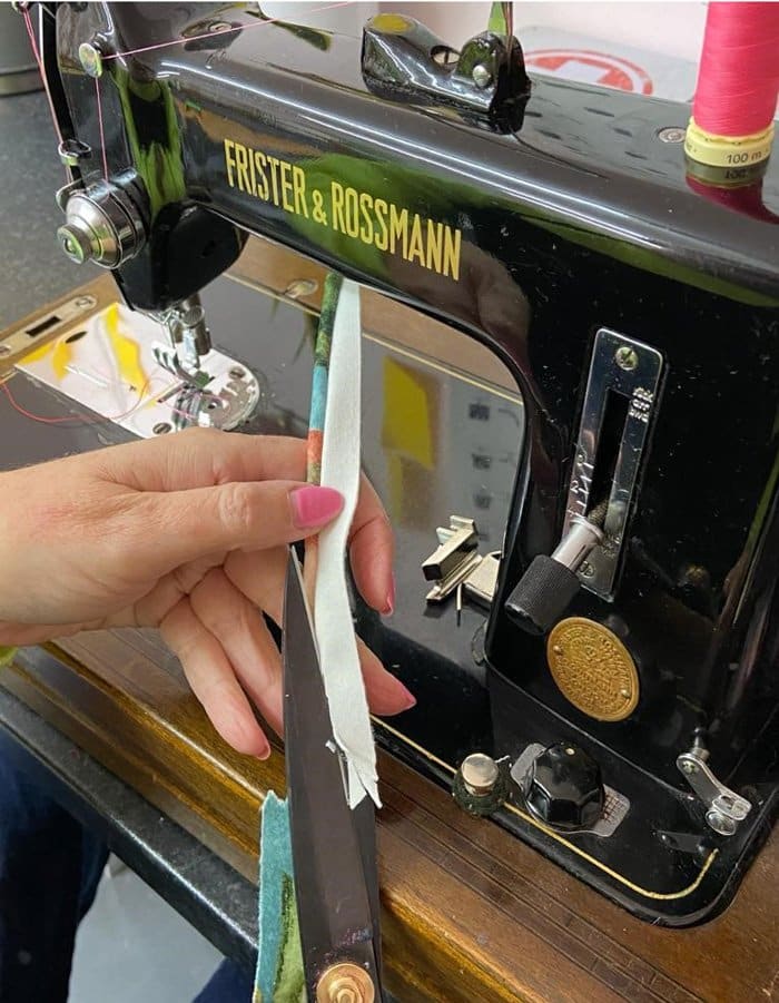 Black sewing machine with fabric being used for double piping