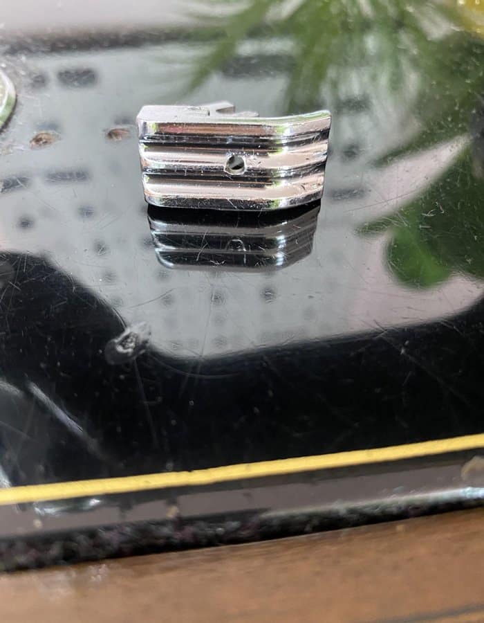 Piece of metal with hole in the middle for double piping for upholstery