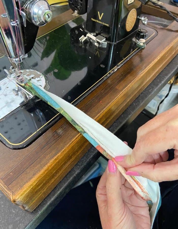 Hands holding fabric which will be used for upholstery using double piping