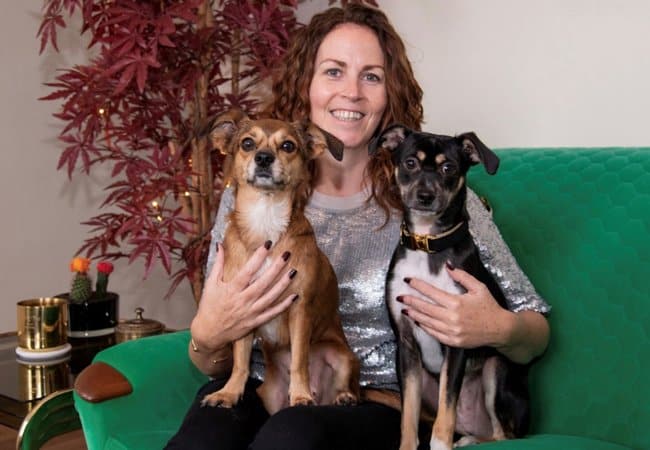 Sharon O'Connor sitting on her couch with her two dogs