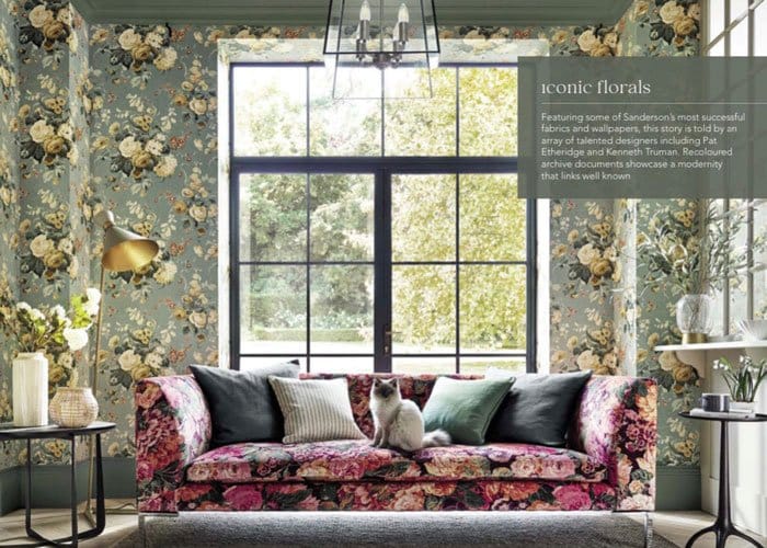 Maximalist interior with floral wallpaper and pink sofa with a cat