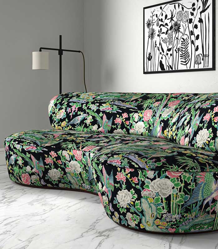 Green and black floral upholstered velvet sofa in a grey room