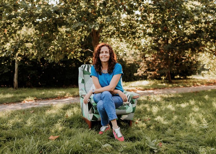 Vintique Upholstery personal branding photoshoot: Sharon O'Connor sat on a reupholstered chair in a park