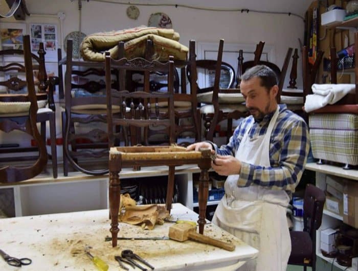 Upholsterer Robbie Richardson working on an upholstered chair