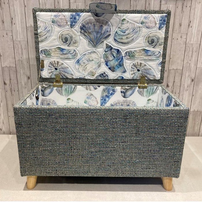 buttoned ottoman upholstered with a seashell fabric