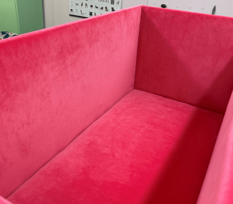 Pink velvet lines the inside of an ottoman