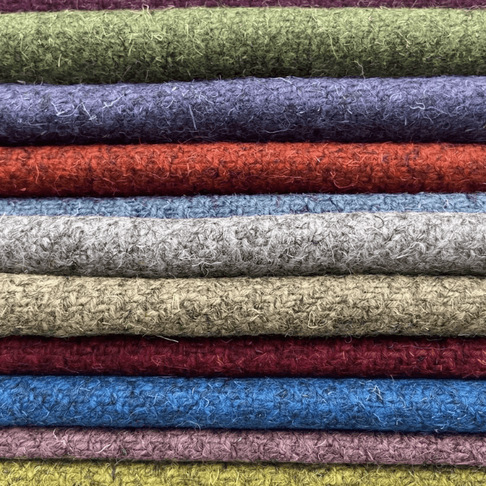 A stack of sustainable fabrics from Cable and Blake in assorted colours