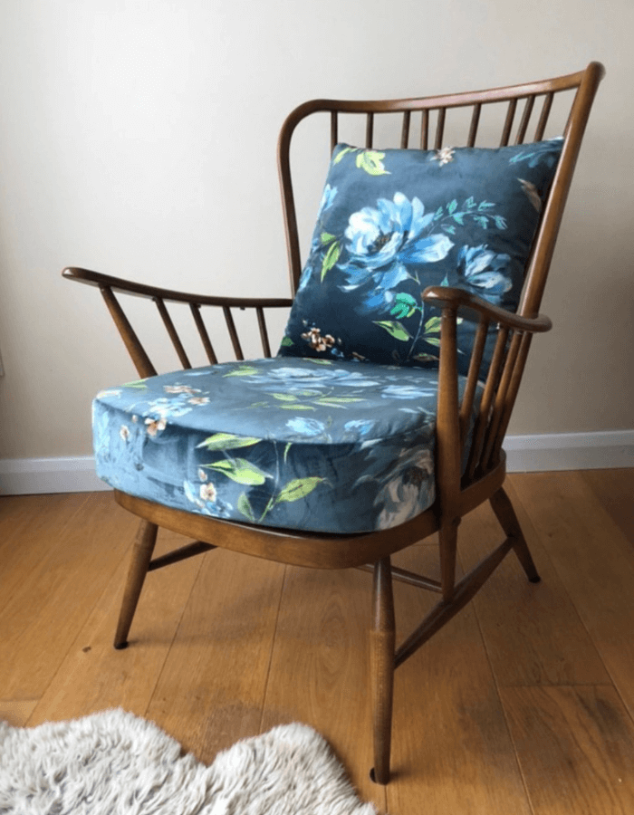 An Ercol statement chair reupholstered in floral blue velvet fabric