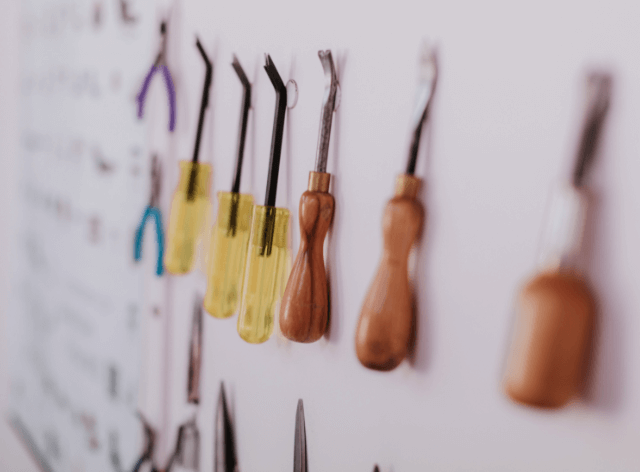 Upholsterers' tools line the wall of a workshop.
