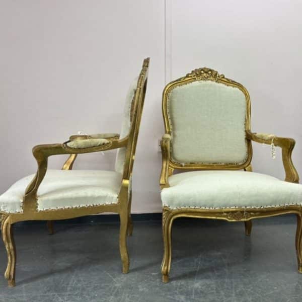 2 antique chairs with gold painted wood and pale fabric in need of reupholstery