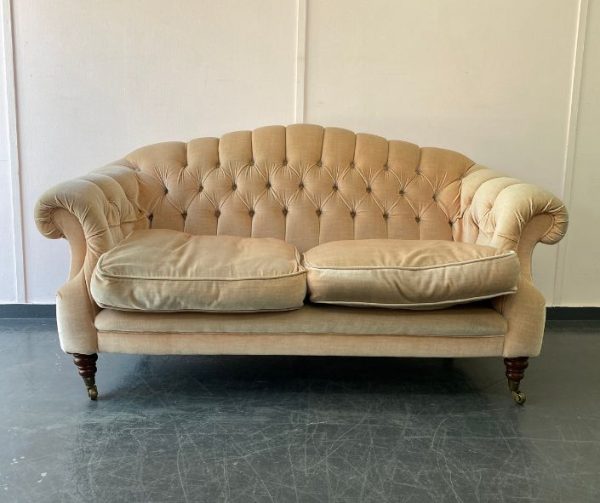 Antique sofa in need of reupholstery in stained neutral fabric