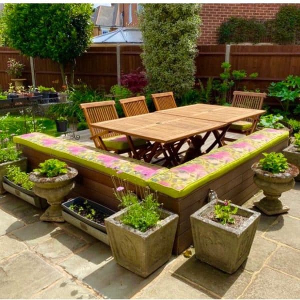 Cushions for garden bench seating – Vintique Upholstery Cushions for garden bench seating in lime green and pink fabric on a bench around the table and chairs