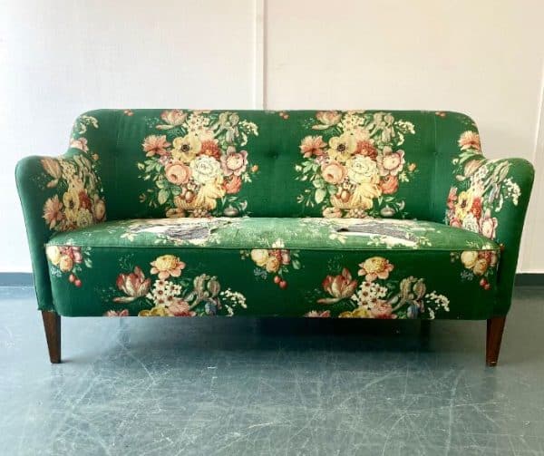 Green floral sofa in need of reupholstery.