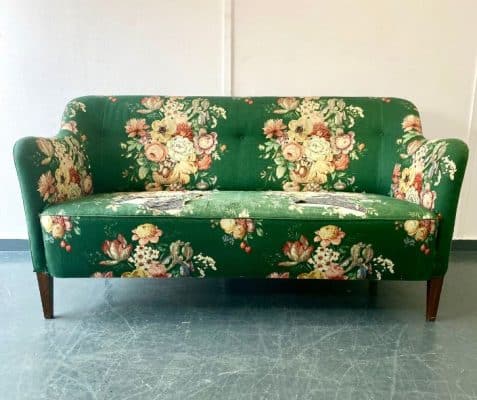 Green floral sofa in need of reupholstery.
