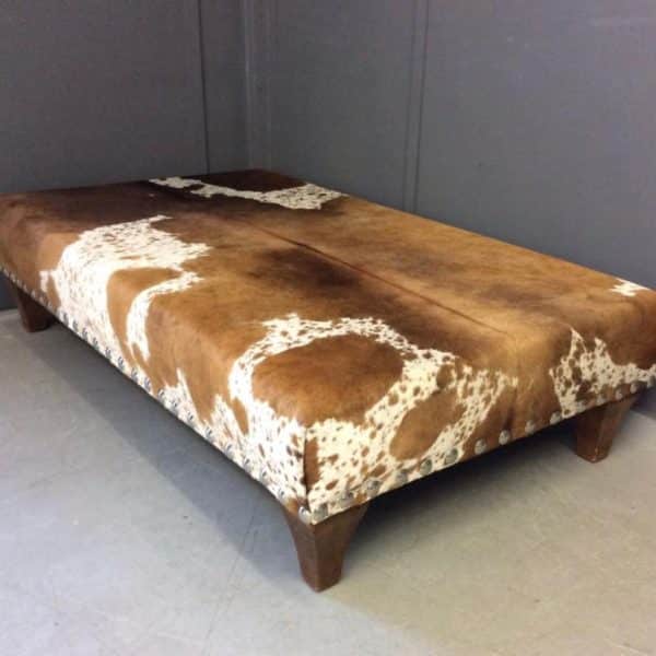 Footstool reupholstered in cowhide Footstool reupholstered in cowhide