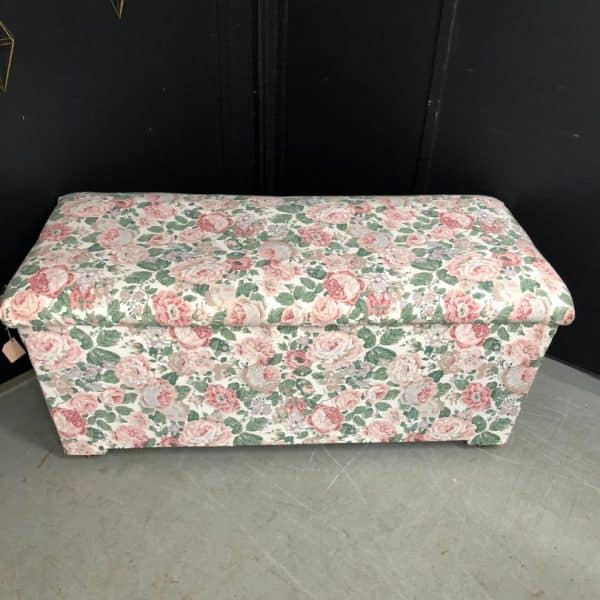 Floral fabric ottoman ready for reupholstery.