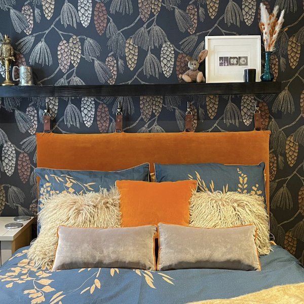 Reupholstered Bed in orange velvet, with custom cushions – Vintique Upholstery Reupholstered Bed in orange velvet, with custom cushions against a dark patterned wallpaper