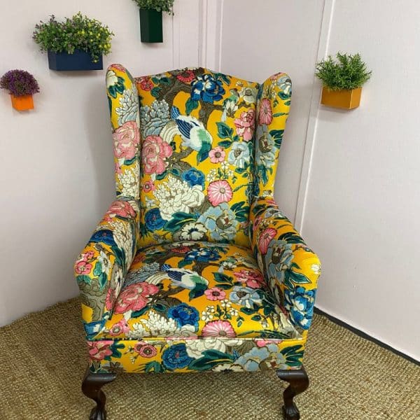 Reupholstered wing backed chair in a floral and bird print