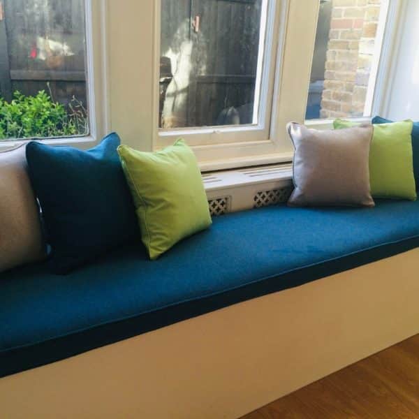 Window seat and cushions – Vintique Upholstery Window seat in a dark blue fabric and cushions in assorted plain fabrics