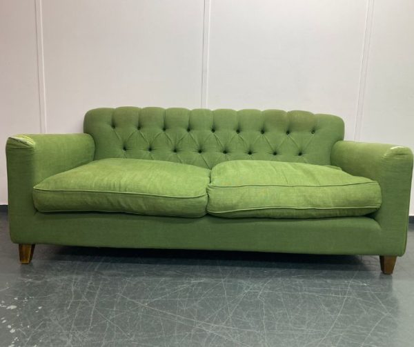 green, button backed sofa in need of reupholstery
