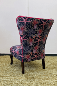 Pink piping lines the back of the chair to accentuate the natural curves of the chair.