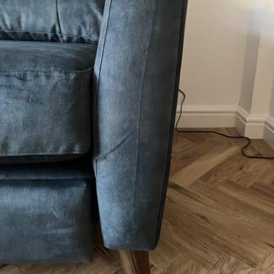Blue velvet sofa showing compression marks as a result of improperly stored fabric.