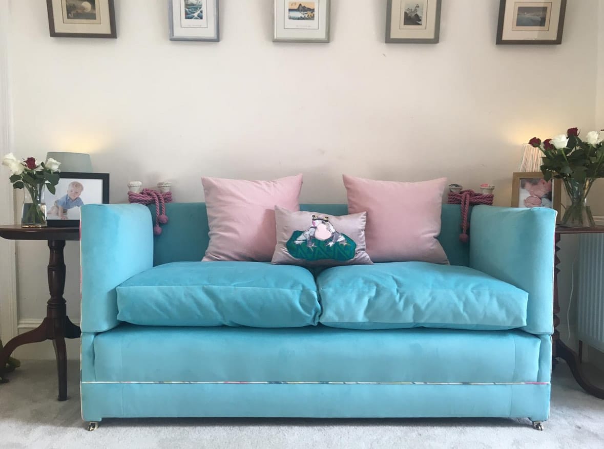 A blue velvet sofa that has been reupholstered by an expert