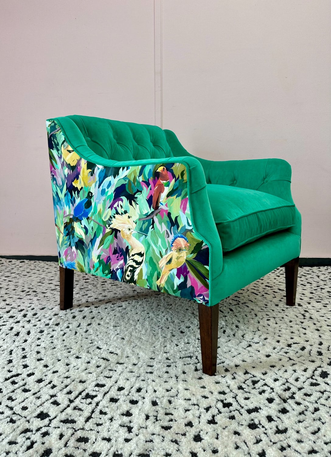 A beautiful green chair with a harlequin print that has been reupholstered by an expert