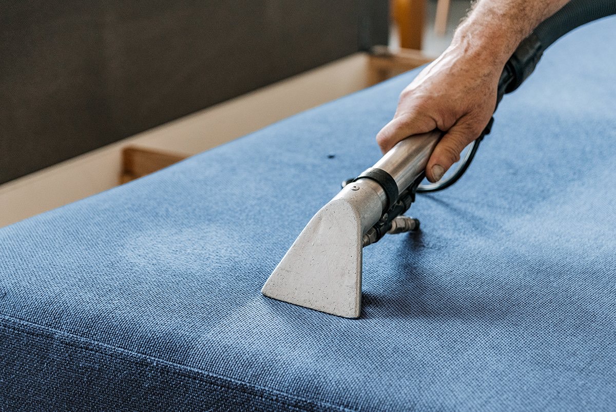 A reupholstered sofa that is being cleaned