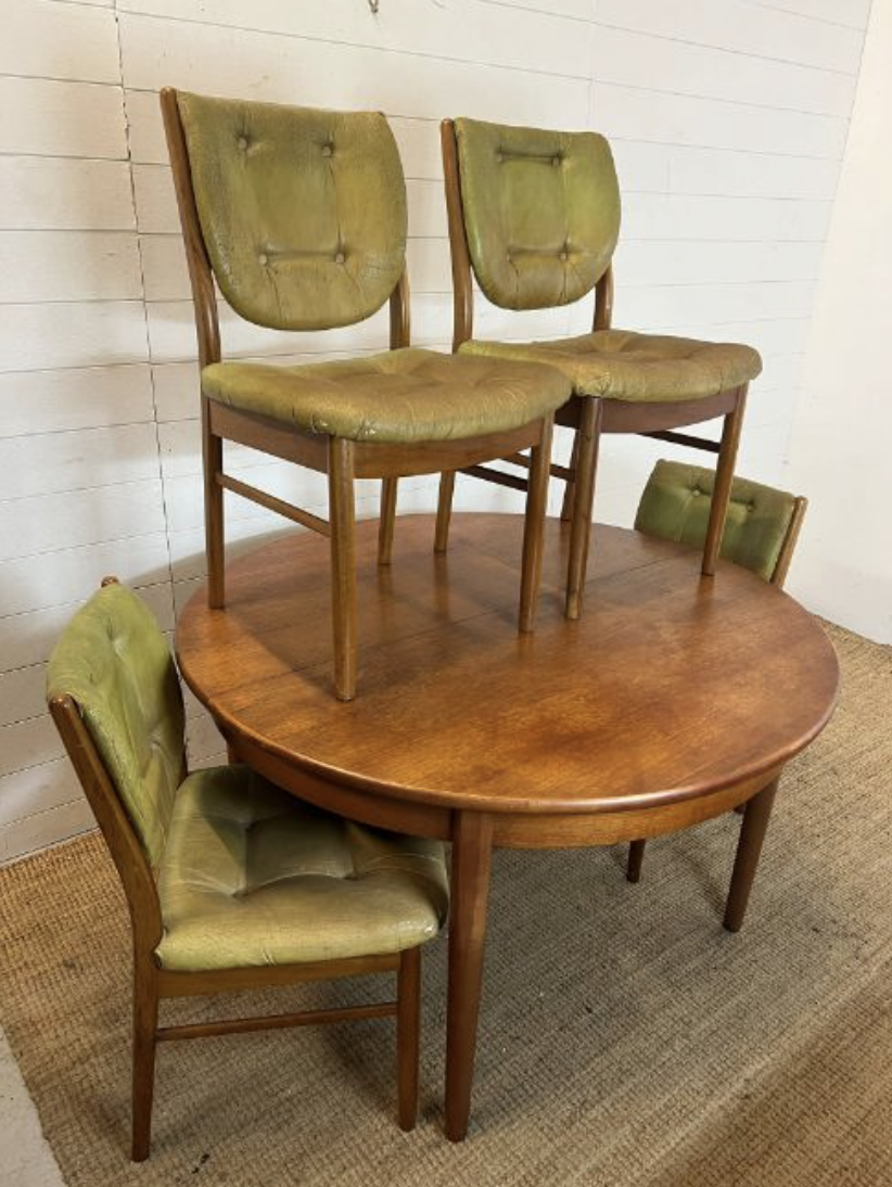 A Mid Century teak circular extending table with four balloon back chairs