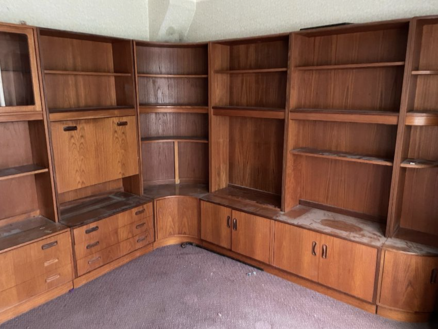 A Mid Century wall unit made by G-Plan comprising of four units, one glazed display unit, one drinks cabinet, two book cases and a corner unit.