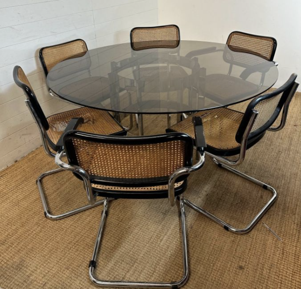 A 1970's Richard Young for Merrow Associates chrome and glass topped circular dining table along with six cane and chrome tubular framed chairs.