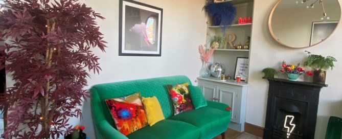 Mid century sofa reupholstered in a green fabric in a sitting room