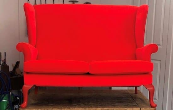 Reupholstered Parker Knoll sofa in neon red fabric