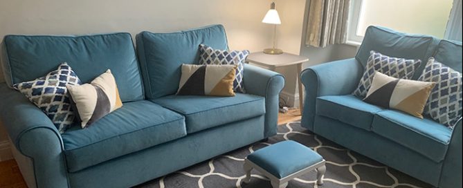 Blue fabric sofas and foot stool in living room