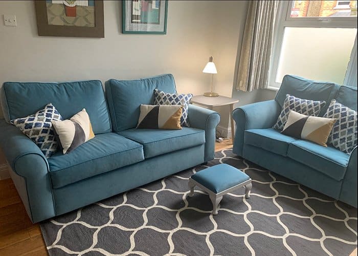 Blue fabric sofas and foot stool in living room