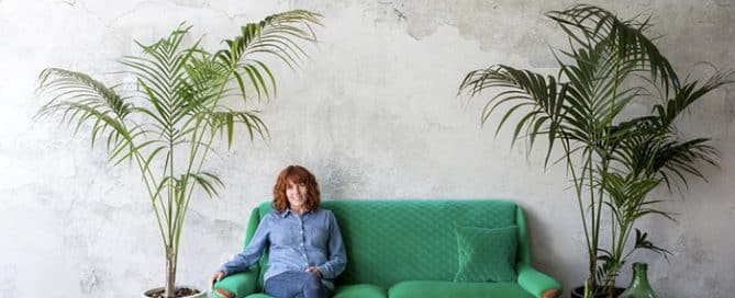 Sharon O'Connor sat on reupholstered green fabric sofa