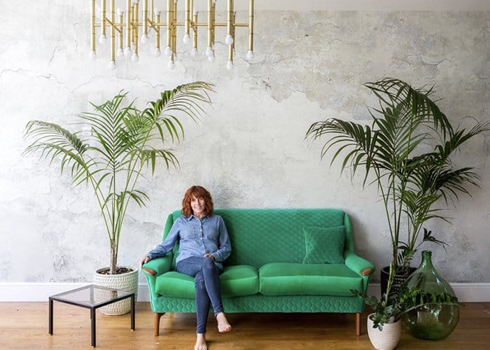 Sharon O'Connor sat on reupholstered green fabric sofa