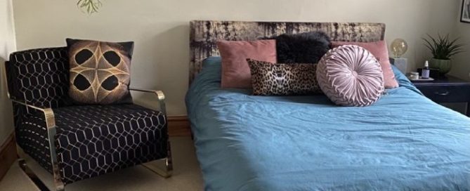 Armchair and bed with reupholstered cushions in bedroom