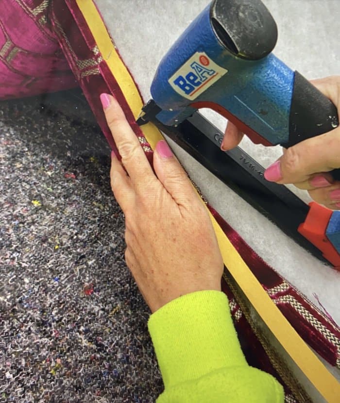 Stapling upholstery single piping onto chair with a staple gun
