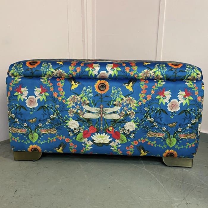 an upholstered ottoman with a flowery themed pattern