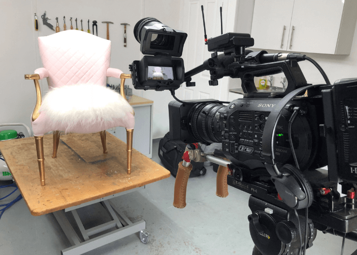 The Vintique Upholstery workshop during filming of BBC Money For Nothing show showing a camera filming an armchair with gold painted legs covered in pink fabrics